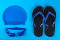 Flat lay composition with swimming accessories on blue background