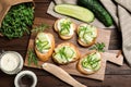 Flat lay composition of tasty bruschettas with cucumbers on table