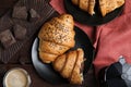 Flat lay composition with tasty croissants, chocolate and coffee on wooden table