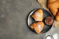 Flat lay composition with tasty croissants, chocolate paste and sugar powder on grey table. Space for text