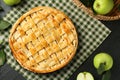 Flat lay composition with tasty homemade apple pie and ingredients on dark textured table Royalty Free Stock Photo