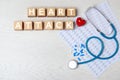 Flat lay composition with text Heart Attack made of cubes and stethoscope Royalty Free Stock Photo
