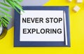 Flat lay composition with text Never stop exploring on white paper above Notebook , Top view Royalty Free Stock Photo