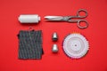 Flat lay composition with thimbles and different sewing tools on red background Royalty Free Stock Photo
