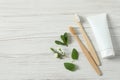 Flat lay composition with toothbrushes and herbs on white wooden table. Space for text Royalty Free Stock Photo