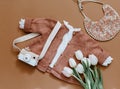 Flat lay composition with tulips, girl knitted jacket and wooden camera.