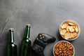 Flat lay composition with video game controller, snacks and space for text on grey