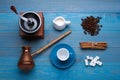 Flat lay composition with vintage manual coffee grinder and turkish pot on light blue wooden background