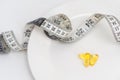 Flat lay composition with weight loss pills, plate and measuring tape on white background Royalty Free Stock Photo