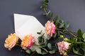 Flat lay composition with a white envelope, blank card and a peony rose flower on a grey background Royalty Free Stock Photo