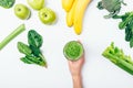 Flat lay composition woman's hand holding glass of green smoothie Royalty Free Stock Photo