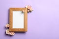 Flat lay composition with wooden photo frame and beautiful flowers on color background Royalty Free Stock Photo