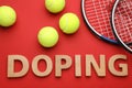 Flat lay composition with word Doping, tennis balls and rackets on red background