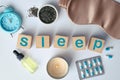 Flat lay composition with word Sleep made of wooden cubes and insomnia remedies on white background Royalty Free Stock Photo