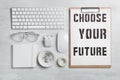 Flat lay composition with words CHOOSE YOUR FUTURE, computer keyboard and stationery on wooden table. Career concept Royalty Free Stock Photo