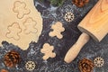 Flat lay concept for baking Christmas cookies with rolled out cookie dough, cookies in the shape of happy gingerbread men Royalty Free Stock Photo
