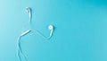Flat lay concept: headphones on pastel backgrounds. white headphones on a blue background, top view, copyspace Royalty Free Stock Photo