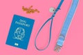 Concept of travelling with dogs showing made up blue dog passport next to collar, leash and treats on pink background