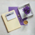 Flat lay concept with writing pad, pen and beautiful violet flowers Royalty Free Stock Photo