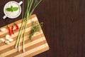 Flat lay cooking image with chopping board, herbs, spices and rice on wooden kitchen table Royalty Free Stock Photo