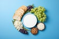 Flat lay cottage cheese, grape, bread, apple, wheat, cheese on blue background