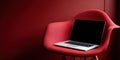 Laptop resting on modern red eames chair Royalty Free Stock Photo
