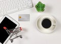 Flat lay of Credit card, computer keyboard, shopping card on digital tablet, a cup of black coffee, succulent plant pot on white Royalty Free Stock Photo