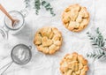 Flat lay crispy shortcrust pastry apple tartlets on light background, top view. Valentine`s day baking