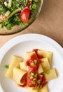 Flat lay. Cropped photo of a healthy vegan meal consisting of vegetarian herb salad and cooked italian pasta with tomato sauce and Royalty Free Stock Photo