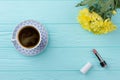 Flat lay cup of coffee with flowers and lipstic.