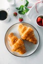 Flat lay of cup of coffee, freshly baked croissants, strawberry on table. Top view Royalty Free Stock Photo