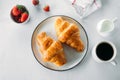 Flat lay of cup of coffee, freshly baked croissants, strawberry on table. Top view Royalty Free Stock Photo