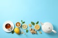 Flat lay. Cup of tea, teapot, lemon, ginger, mint, honey and dipper on blue background Royalty Free Stock Photo