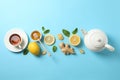 Flat lay. Cup of tea, teapot, lemon, ginger, mint, honey and dipper on blue background Royalty Free Stock Photo