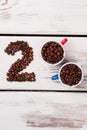 Flat lay cups with coffee beans and number two. Royalty Free Stock Photo