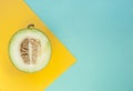 Flat lay of cut melon on blue and yellow background. Royalty Free Stock Photo