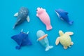 Flat lay of cute aquarium whale, turtle, ray, dolphin, seal toy eraser set on blue background minimal style. Kid learning Royalty Free Stock Photo