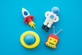 Flat lay of cute astronaut, rocket, robot and planet outer space eraser toy set on blue background minimal style. Imagination Royalty Free Stock Photo