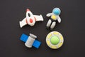 Flat lay of cute astronaut, rocket, satellite and ufo outer space eraser toy set on black background minimal style. Imagination Royalty Free Stock Photo
