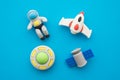 Flat lay of cute astronaut, rocket, satellite and ufo outer space eraser toy set on blue background minimal style. Imagination Royalty Free Stock Photo