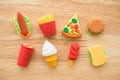 Flat lay of cute various fast food products and drinks eraser toy set on wooden background minimal style. Kid learning Royalty Free Stock Photo