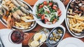 Flat lay of Cyprus fish and seafood meze with olives, lemon and Greek salad Royalty Free Stock Photo