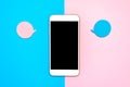 Flat lay design with blank on a smart phone with bubbles for text messages. Minimalist blue and pink background. Conversation idea