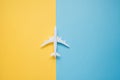 Flat lay design of travel concept with plane on blue and yellow background with copy space. Royalty Free Stock Photo