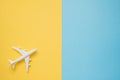 Flat lay design of travel concept with plane on blue and yellow background with copy space. Royalty Free Stock Photo