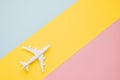 Flat lay design of travel concept with plane and cloud on blue, yellow and pink background with copy space. Royalty Free Stock Photo