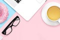 Flat lay design of work desk with laptop notebook, tea mug, eye glasses on pastel pink and blue background. Minimal