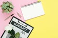 Flat lay design of working space - Top view mockup of contract document, pen and white paper notebook with rose and tree on pink Royalty Free Stock Photo