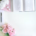 Flat lay with different accessories; flower bouquet, pink roses, open book, Bible