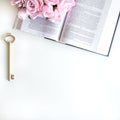 Flat lay with different accessories; flower bouquet, pink roses, open book, Bible